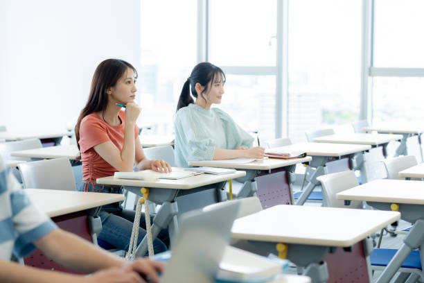 istock University student talking to classmates in classroom 2172291885