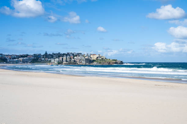 Capture the essence of summer with an aerial view of people relaxing on Bondi Beach, Sydney, under a dramatic afternoon sky, enjoying the sun and surf.