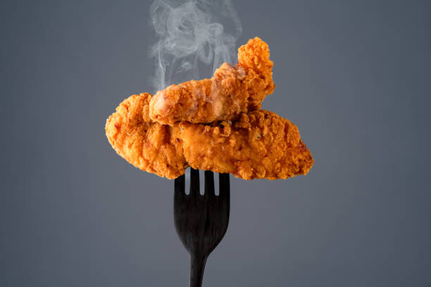 Chicken tenders on fork. Fried chicken breast strips. Isolated chicken crisps