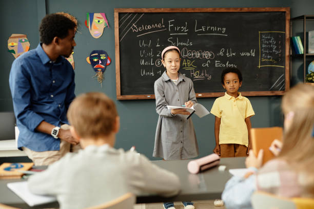istock Boy and Girl Presenting Homework Results to Class in Classroom 2172310332