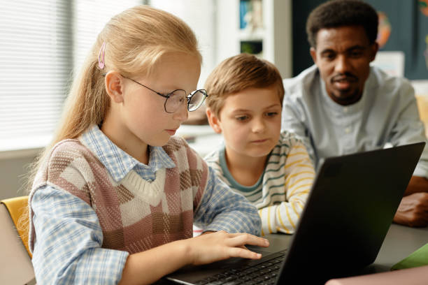 istock Girl Using Laptop in Class Studying with Classmate in Classroom 2172310437