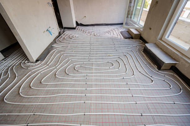 istock View on thin white tubes bended in complex curve of new brass, distribution system manifold mounted for central heating floor in a residential building under construction. 2172313761