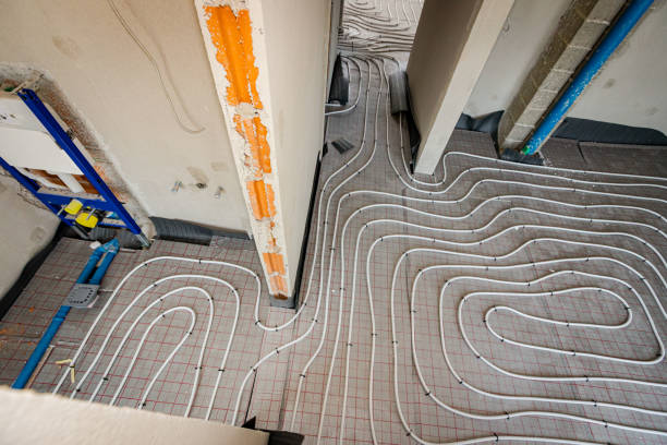 istock View on thin white tubes bended in complex curve of new brass, distribution system manifold mounted for central heating floor in a residential building under construction. 2172313888