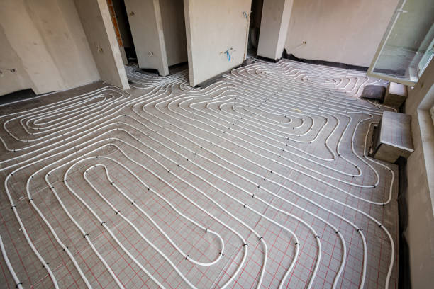 istock View on thin white tubes bended in complex curve of new brass, distribution system manifold mounted for central heating floor in a residential building under construction. 2172313981