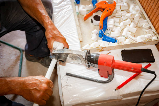 istock Hands of worker as holding plastic water pipes in device for melting, welding 2172314176