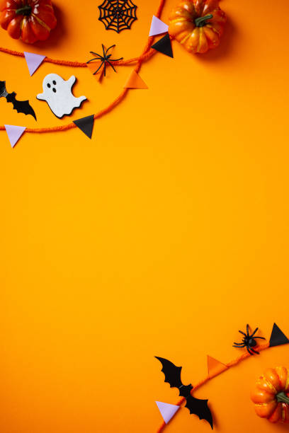 istock Halloween holiday flat lay composition with paper garland, decorations, bats, ghosts, spiders on orange background. Halloween vertical banner design, poster template 2172314501