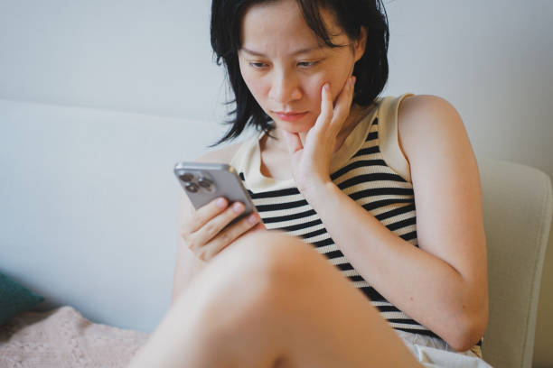 istock Young Asian woman using smartphone at home 2172314765