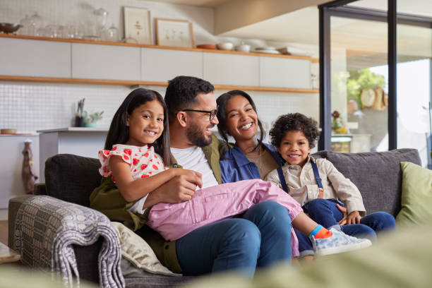 istock Happy family with kids sitting on sofa 2172316112