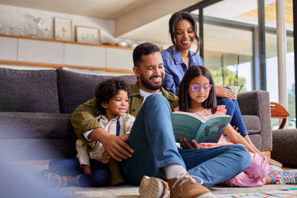 indian father reading a story to his children at home - lezen fotos stockfoto's en -beelden
