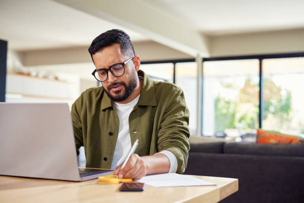 Businessman working on laptop at home with copy space