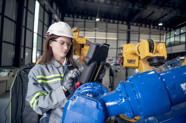 istock Engineer standing by robotic arm and operating machine in industry factory, technician worker check for repair maintenance electronic operation 2172317217