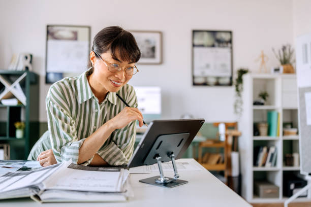 istock Smiling beautiful woman using digital tablet while working at home office 2172317327