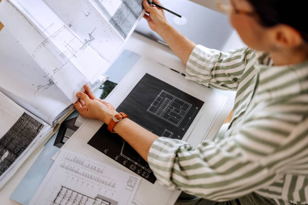 istock Casually clothed female architect analysing plans at the office 2172318584
