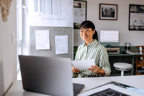 istock Smiling beautiful female architect having video call while working at home office 2172318840