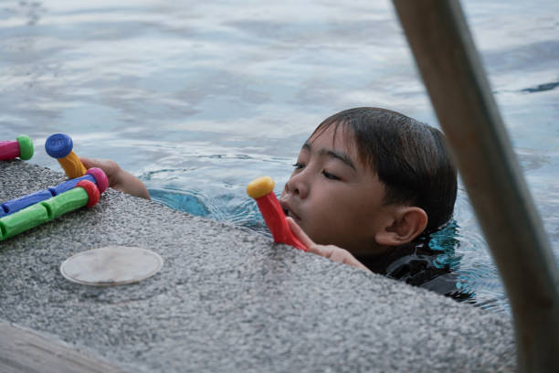 istock Boy holding multicolored stick in the pool 2172319041