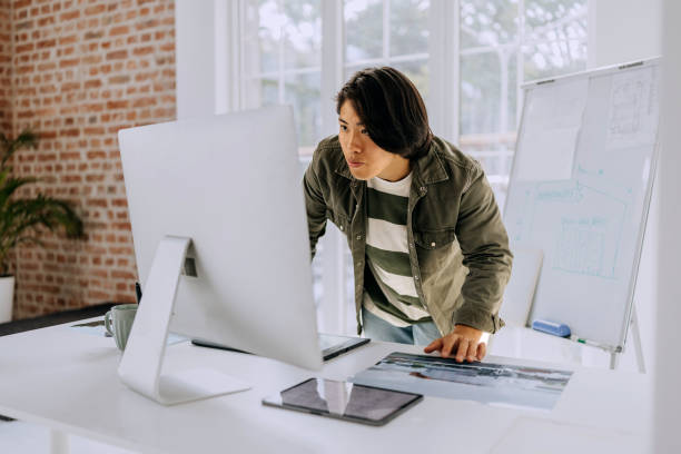istock Young casually clothed man working on desktop PC at modern office 2172319175