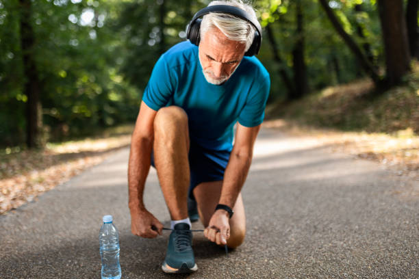 istock Senior Man Tying Running Shoes Before Workout 2172319808