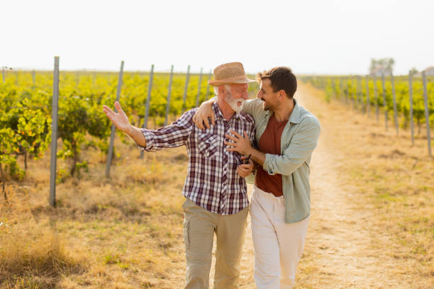 istock Two men stroll through a sunlit vineyard, sharing laughter and stories on a warm afternoon, surrounded by lush green vines 2172319883