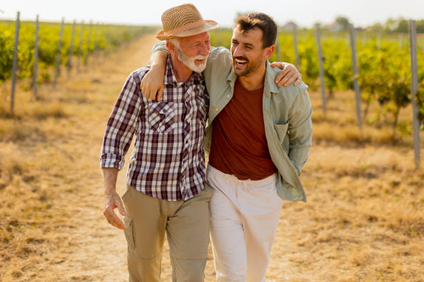 istock Two men stroll through a sunlit vineyard, sharing laughter and stories on a warm afternoon, surrounded by lush green vines 2172319892