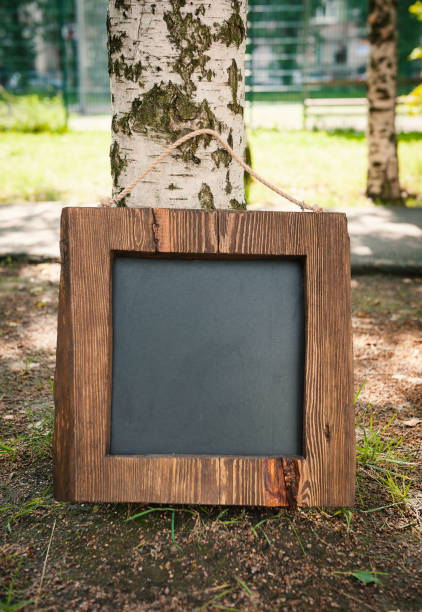 Empty black blackboard with wooden frame outdoor. Template Mock up