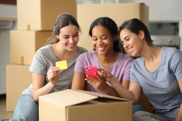 istock Three happy roommates buying online while moving home 2172324019