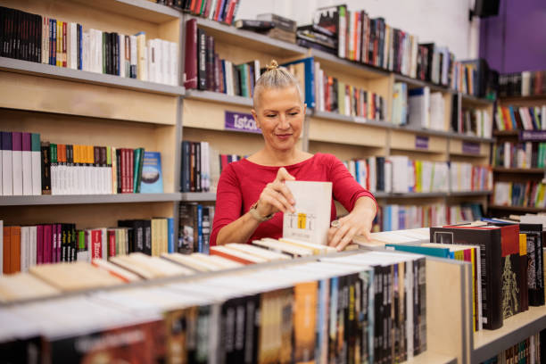 A mid adult Caucasian woman looking at books in a local bookstore