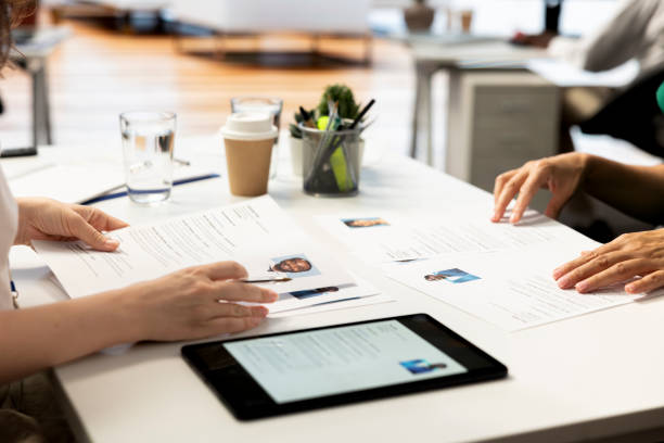 istock Talent acquisition experts looking at CVs on tablet to vet applicants 2172325563