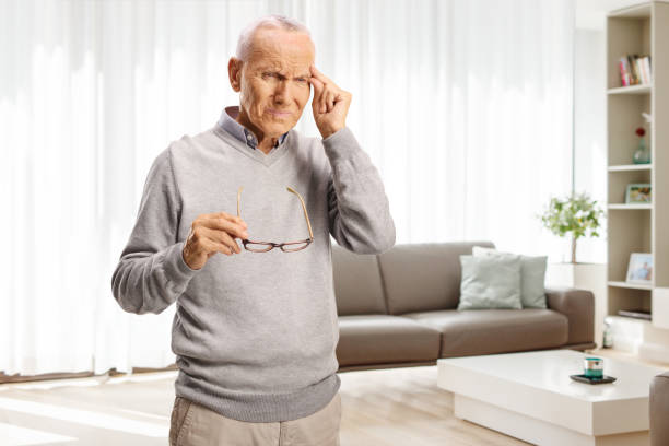 istock Elderly man with headache holding his forhead at home 2172326129