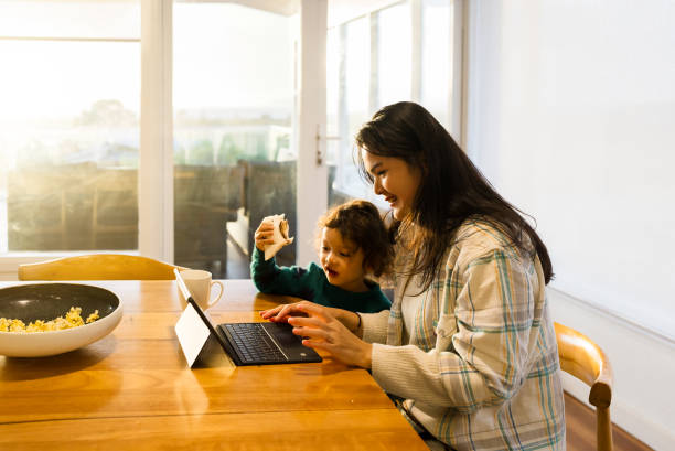 istock parent  looking onto laptop with kids 2172326303