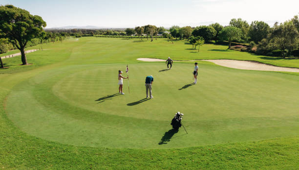 istock Golf group playing golf from the green at a sunny golf course surrounded by sand bunkers 2172328590