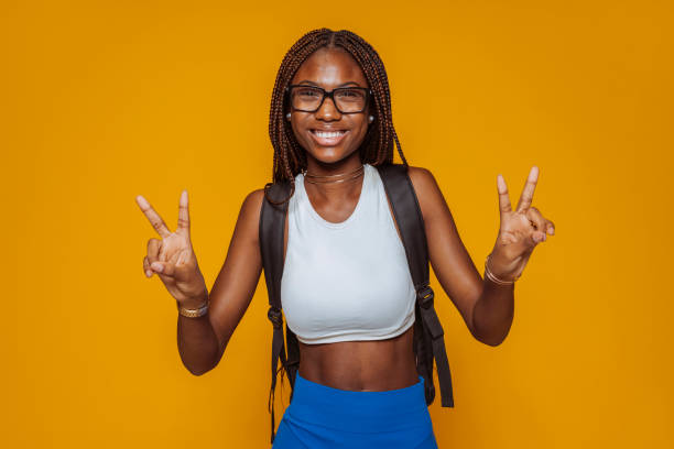 istock Cheerful african female student does peace victory sign with hands 2172328788