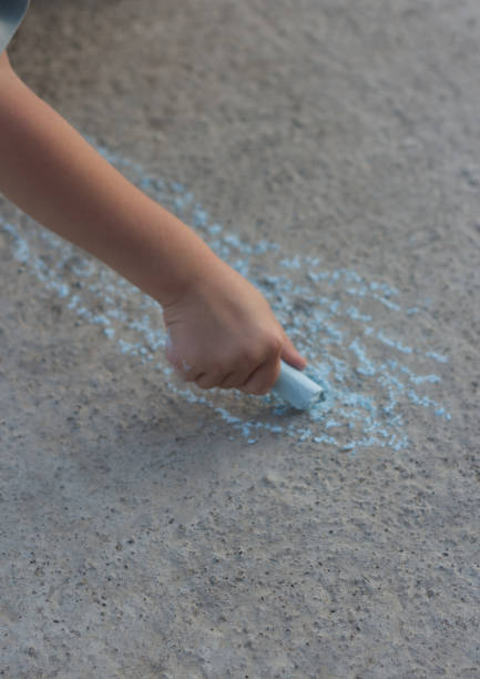 istock A child draws on the asphalt with crayons in summer 2172331119