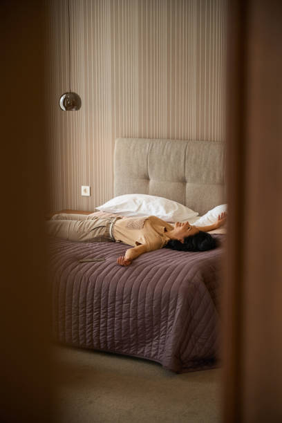 istock Woman in comfortable casual clothes is lying on a bed 2172334183