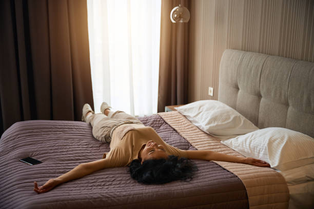 istock Brunette in travel clothes resting from the road on bed 2172334191