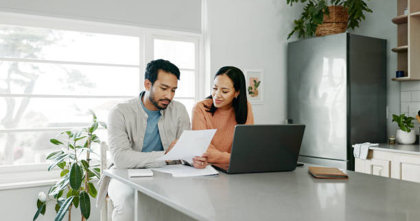 istock Kitchen, couple and conversation with document for finance, track expenses and laptop for budget goal. Discussion, man and woman with tax paper for checking, mortgage review or handle savings at home 2172335378