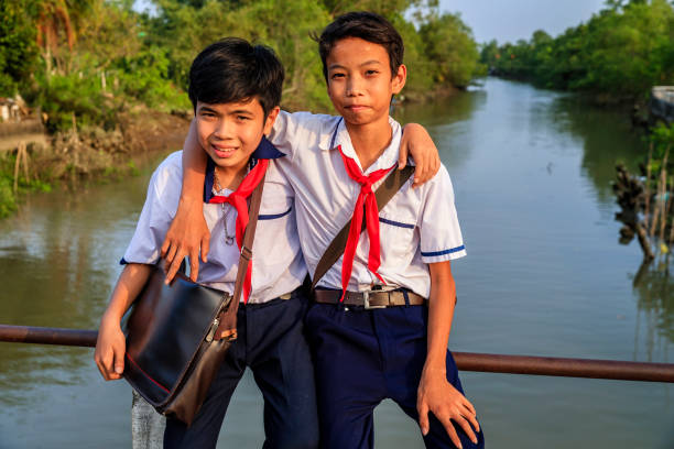 istock Two Vietnamese schoolboys sitting on a bridge, Mekong River Delta, Vietnam 2172336868