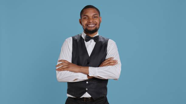 istock Confident cheerful hotel concierge staff poses with arms crossed in studio 2172342951
