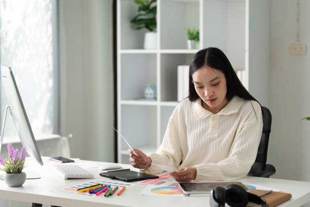 istock Young Female Designer Working on Creative Project in Modern Office with Digital Tablet and Color Swatches 2172344834