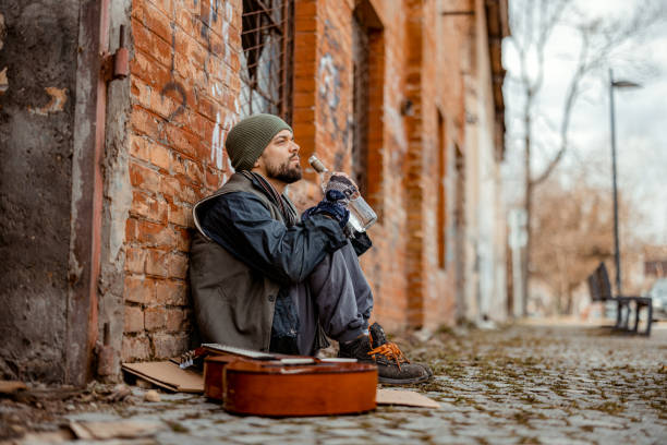 Homeless Man Sitting in Front of an Abandoned Building