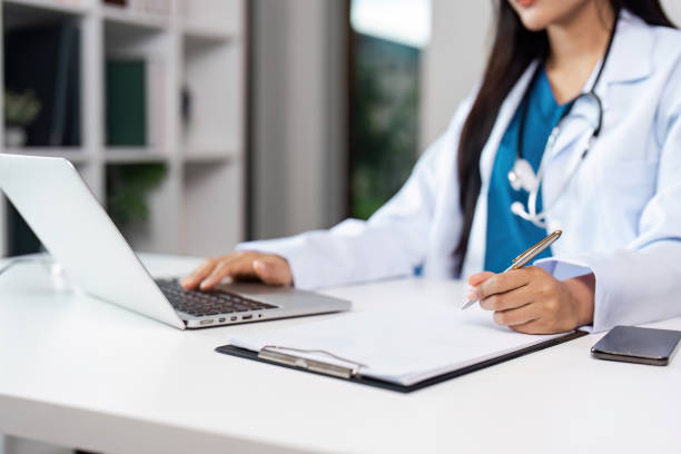 istock Professional Doctor Working on Laptop and Writing Notes in Modern Medical Office 2172345995