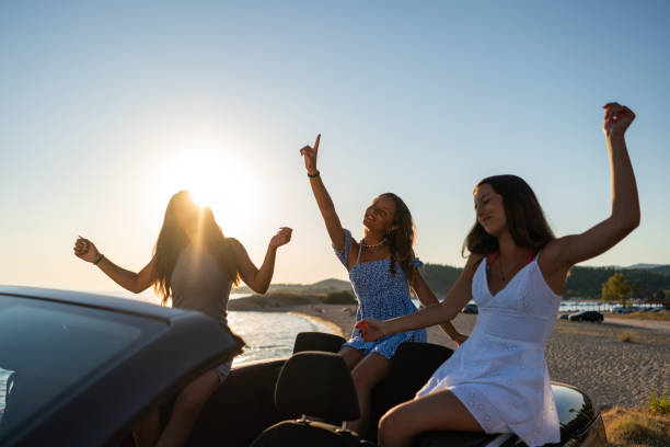 istock Girls dancing and singing in a convertible 2172348633