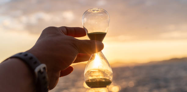 istock Sunset sea and hourglass 2172351384