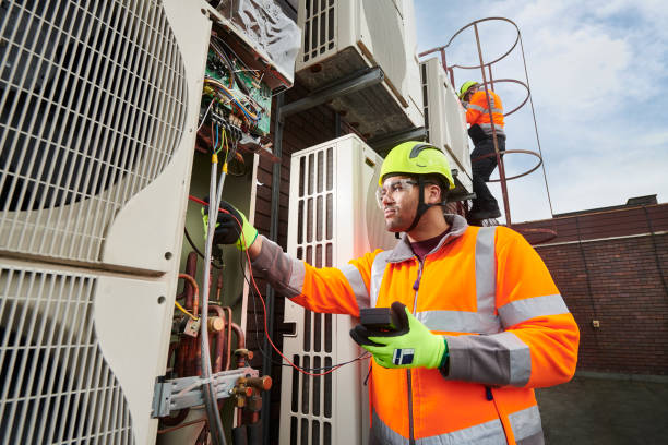 maintenance engineers servicing air conditioning units - eletricista imagens e fotografias de stock