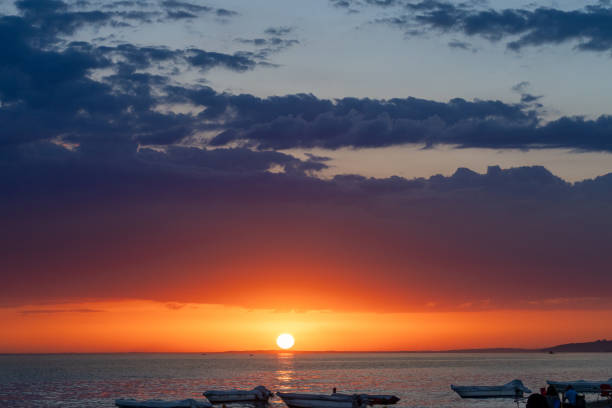 Dramatic clouds with sunlight beams at sunset period, capture from seaside