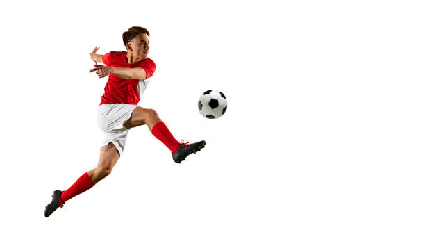 istock Young football player, wearing red-white uniform, executing dynamic kick against white studio backdrop with negative space . 2172355192