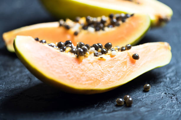 istock Slised papaya with silver spoon on black concrete background 2172356591