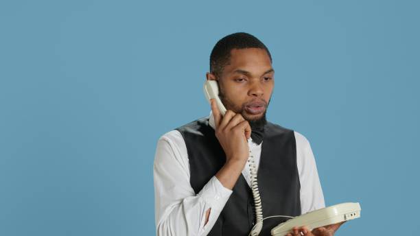 istock Bellboy concierge staff answering landline phone call to make reservations 2172363326