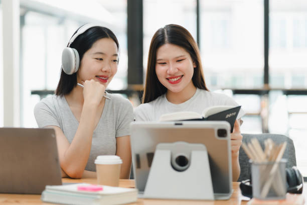 istock Engaged women studying together with tablet and laptop, sharing smiles. 2172364087