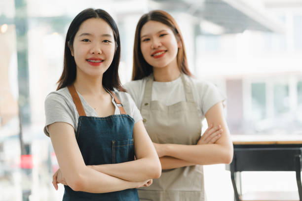 istock Empowered women in aprons smiling confidently in cafe setting 2172364111