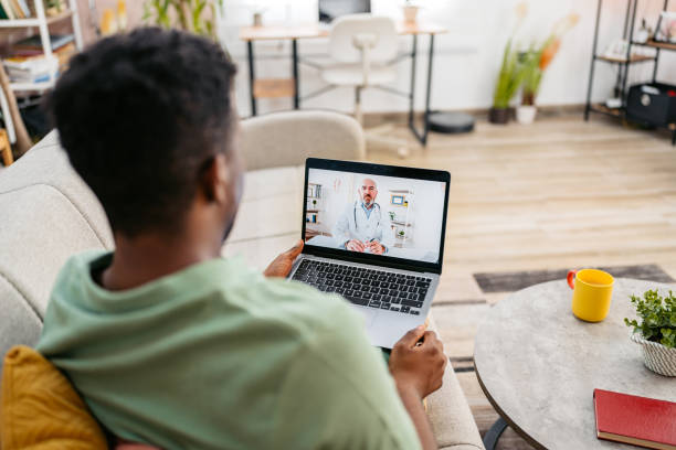 Young Man Having A Doctor's Appointment On The Laptop On The Sofa